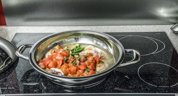 Aggiungere i fagiolini, i cubetti di pomodoro e l'acqua e insaporire con sale e pepe.