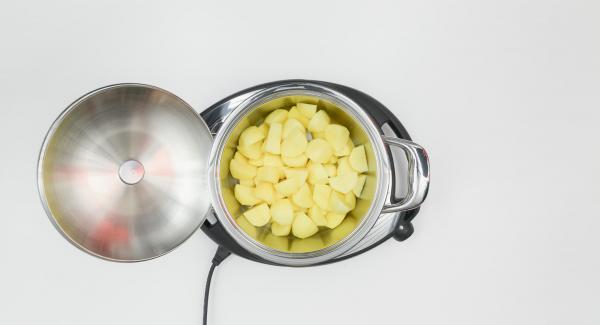 Pelare le patate e tagliarle a pezzetti. Mettere le patate bagnate all'interno dell'Unità di cottura 20 cm 3,0 l.