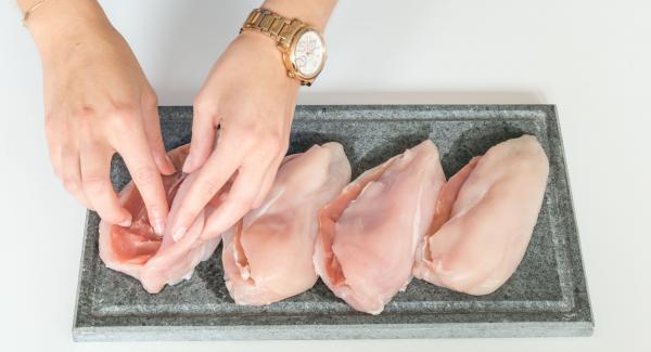 Incidere una tasca nei petti di pollo e inserire in ciascuno una fetta di prosciutto.