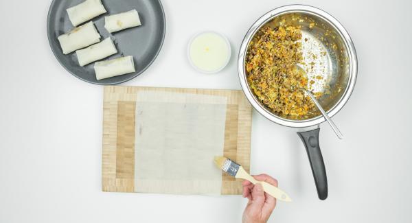 Stendere un foglio di pasta fillo sulla superficie di lavoro. Spennellare velocemente i bordi con l’albume, mettere un cucchiaio di ripieno e arrotolare velocemente fino a formare l’involtino.