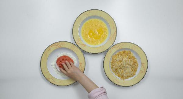 Passare le fette di pomodoro dapprima nella farina, poi nelle uova e, infine, nel miscuglio di pangrattato e cornflakes.