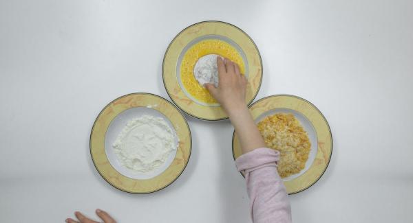 Passare le fette di pomodoro dapprima nella farina, poi nelle uova e, infine, nel miscuglio di pangrattato e cornflakes.