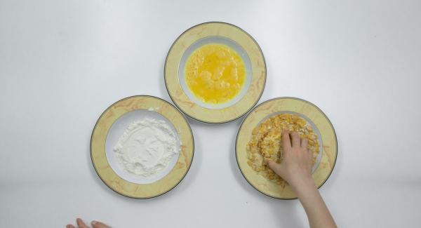 Passare le fette di pomodoro dapprima nella farina, poi nelle uova e, infine, nel miscuglio di pangrattato e cornflakes.