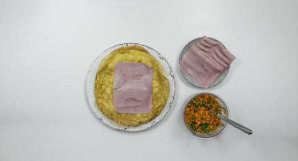 Disporre una fetta di prosciutto su ciascuna crêpe, spalmarvi sopra un cucchiaio del composto di carote e arrotolare ben stretto.