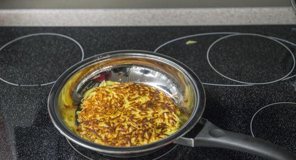 Togliere il coperchio, controllare se il rösti si stacca facilmente dal fondo e se è dorato a sufficienza. Far scivolare il rösti su un piatto, eventualmente aggiungere ancora un po’ di burro chiarificato e cuocere il rösti dall’altro lato.