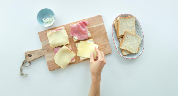 Farcire quattro fette di pane per toast con il formaggio cremoso. Aggiungere il crescione, i germogli o la lattuga. Affettare sottilmente il pomodoro e posizionare una fetta su ciascun toast.