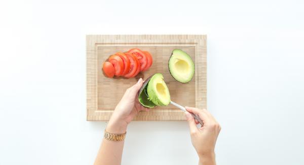 Denocciolare l’avocado, scavare la polpa con un cucchiaio e spalmarla sui toast.