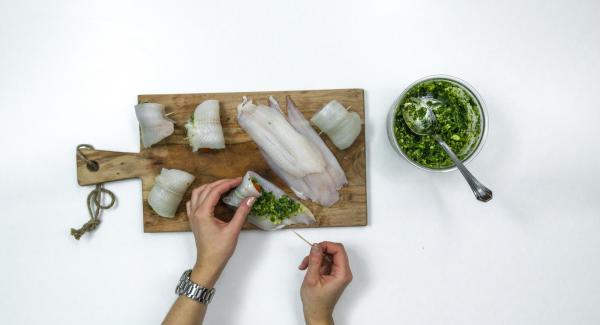 Spalmare un po’ di pesto sui filetti di pesce, disporre un pomodorino su ciascun filetto, arrotolarlo e fissarlo con uno stuzzicadenti.
