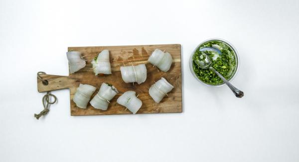 Spalmare un po’ di pesto sui filetti di pesce, disporre un pomodorino su ciascun filetto, arrotolarlo e fissarlo con uno stuzzicadenti.