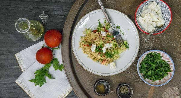 Spezzettare la feta grossolanamente. Tritare le foglie di prezzemolo. Versare la feta sopra l'insalata e cospargere il tutto con il prezzemolo.