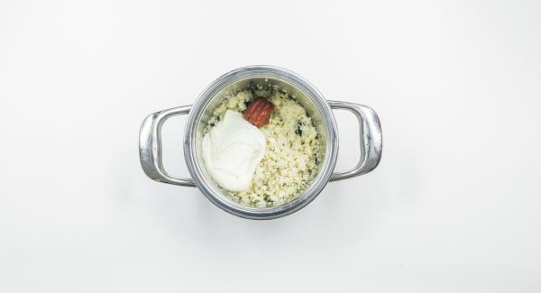 Mescolare couscous, uva passa, cipolla, anacardi, concentrato di pomodoro e crème fraîche e insaporire con sale, pepe, pepe di Cayenna e paprica.