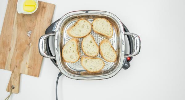 Al suono di Audiotherm, abbassare Navigenio a livello 2, inserire la metà delle fette di pane all'interno dell'Unità di cottura, coprire con il coperchio e tostare per ca. 1 minuto.