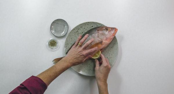 Pepare il pesce all’interno e all’esterno e inserire le fette di limone all’interno.