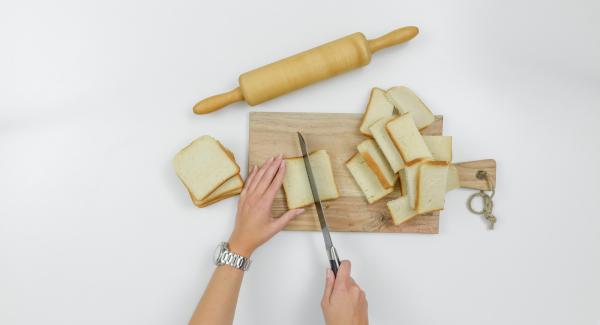 Tagliare a metà le fette di toast e stenderle con il mattarello.
