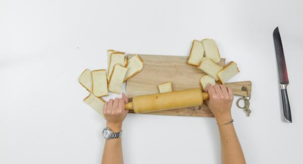 Tagliare a metà le fette di toast e stenderle con il mattarello.