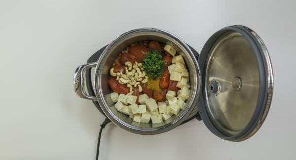 Aggiungere i pomodori, il curry in polvere, gli anacardi e la menta. Infine, aggiungere i pezzetti di tofu.