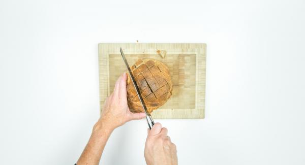 Incidere con una croce il pane sul lato superiore per formare dei quadrati di ca. 2 cm. È importante non tagliare completamente il pane.