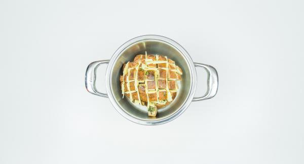 Posizionare il pane all'interno dell'Unità di cottura 20 cm 4,0 l e coprirla con Navigenio rivolto verso il basso, impostato a livello I. Mentre la spia lampeggia, inserire un tempo di 20 minuti su Audiotherm e cuocere al forno fino a ottenere la doratura desiderata.