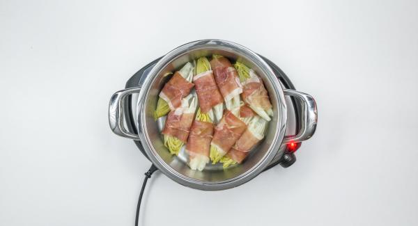 Avvolgere la cicoria nelle fette di prosciutto, adagiarla nuovamente nell’Unità, cospargere con la salsa al formaggio e distribuire sopra il formaggio rimanente.