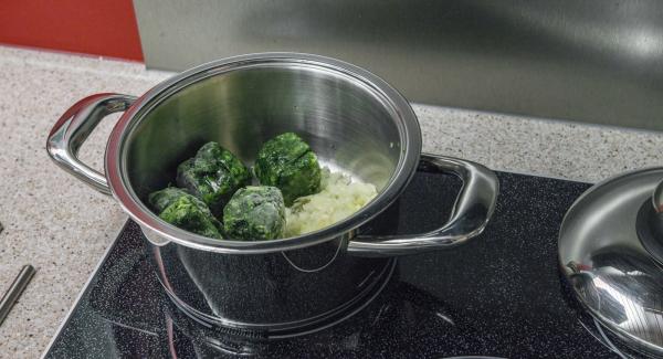 Posizionare all'interno dell’Unità di cottura 20 cm 3,0 l gli spinaci surgelati, 3 cucchiai di acqua e il trito di aglio e cipolla.