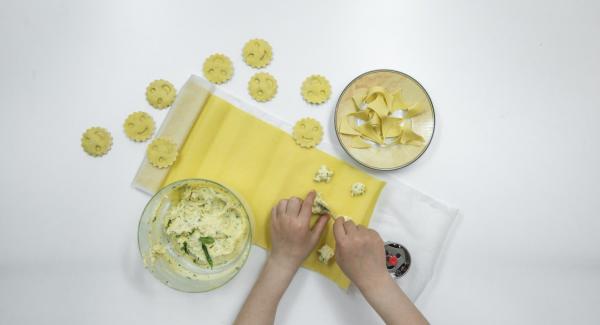 Stendere una sfoglia sottile di pasta e su una metà predisporre lo stampo dei ravioli. Mettere su ogni raviolo una pallina di ripieno e spennellare la pasta tutt’intorno con un po’ di acqua.