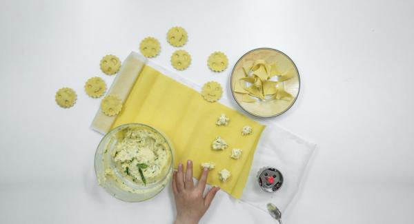 Stendere una sfoglia sottile di pasta e su una metà predisporre lo stampo dei ravioli. Mettere su ogni raviolo una pallina di ripieno e spennellare la pasta tutt’intorno con un po’ di acqua.