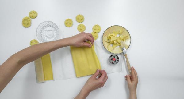 Coprire con cura con la seconda sfoglia di pasta e premere con gli stampini per inserire il ripieno. Tagliare i ravioli.