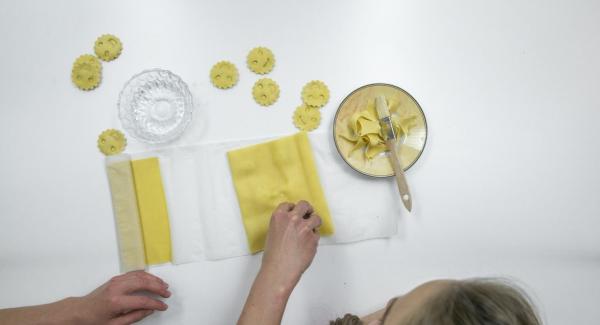 Coprire con cura con la seconda sfoglia di pasta e premere con gli stampini per inserire il ripieno. Tagliare i ravioli.