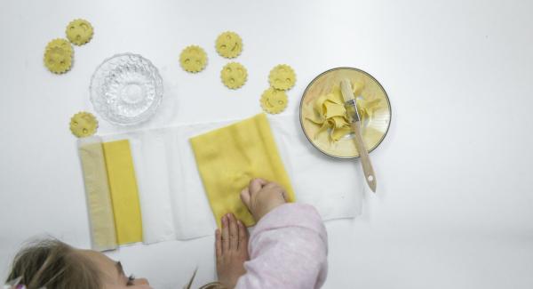 Coprire con cura con la seconda sfoglia di pasta e premere con gli stampini per inserire il ripieno. Tagliare i ravioli.