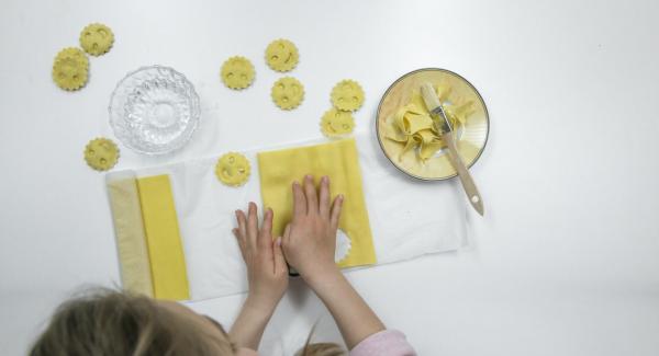 Coprire con cura con la seconda sfoglia di pasta e premere con gli stampini per inserire il ripieno. Tagliare i ravioli.