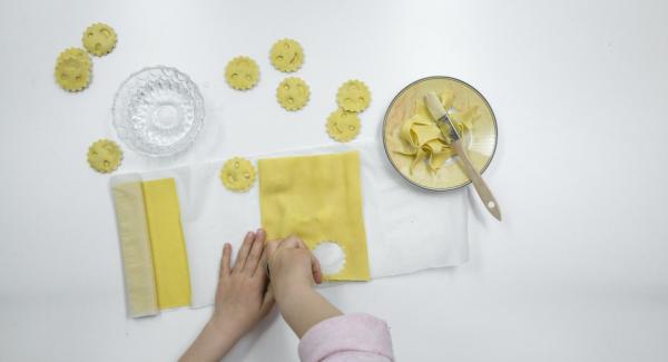 Coprire con cura con la seconda sfoglia di pasta e premere con gli stampini per inserire il ripieno. Tagliare i ravioli.