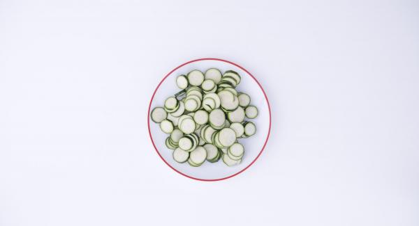 Tagliare le zucchine a rondelle e sciacquarle con acqua.