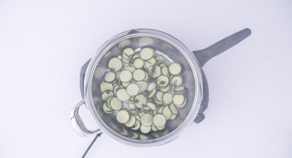 Al suono di Audiotherm, rimuovere il coperchio e far evaporare l'acqua. Aggiungere l'olio e far saltare le zucchine fino a doratura ultimata. Rimuovere l'aglio e servire.
