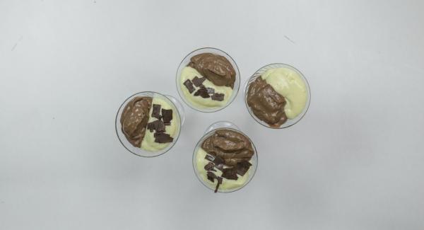 Montare la panna e suddividerla nelle due creme. Versare le creme in quattro bicchieri alternandole e lasciare in frigorifero per un paio d’ore. Cospargere con le granelle di cioccolato e servire.