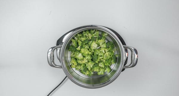 Adagiare i cubetti di patate ancora bagnati all'interno dell'Unità di cottura e i broccoli nell’Inserto 2 in 1. Posizionare l'Inserto sopra l'Unità.