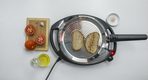 Abbassare Navigenio a livello 2, posizionare due fette di pane su oPan e cuocerle da un lato. Girarle e strofinarvi sopra l'aglio e il pomodoro.