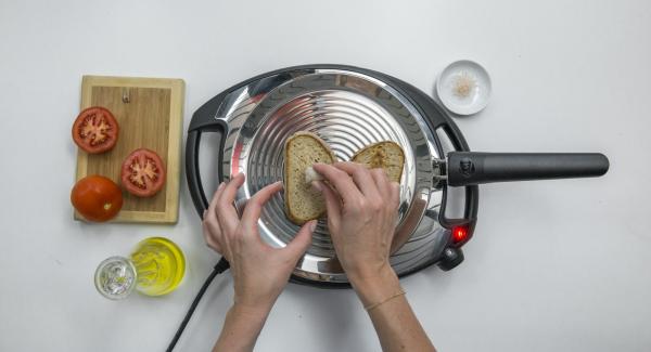 Abbassare Navigenio a livello 2, posizionare due fette di pane su oPan e cuocerle da un lato. Girarle e strofinarvi sopra l'aglio e il pomodoro.