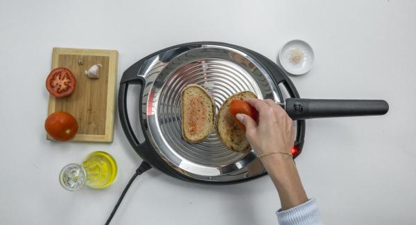 Abbassare Navigenio a livello 2, posizionare due fette di pane su oPan e cuocerle da un lato. Girarle e strofinarvi sopra l'aglio e il pomodoro.