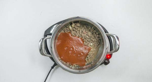 Al suono di Audiotherm, abbassare Navigenio a livello 2 e rosolare la carne con il trito di cipolla e aglio. Quindi aggiungere il mais e la passata di pomodoro.