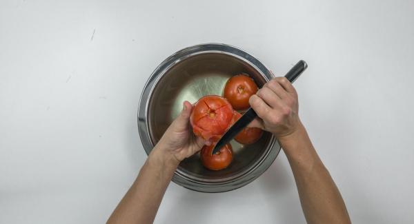 Scottare i pomodori in acqua bollente, spellarli e tagliarli grossolanamente.