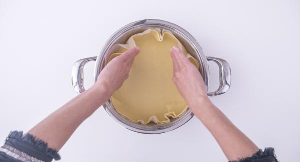 Lavorare la pasta frolla, stenderla e posizionarla all'interno dell'Unità di cottura 24 cm 2,5 l  su un disco di carta da forno leggermente più grande del fondo dell'Unità.