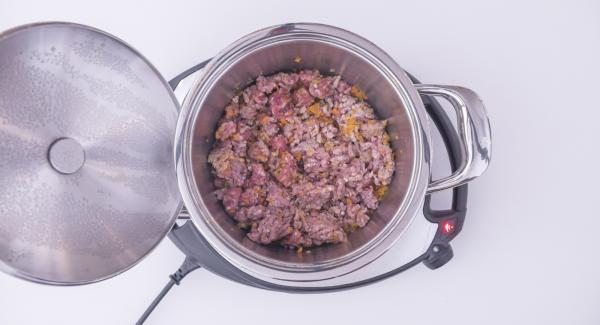 Al suono di Audiotherm, abbassare Navigenio a livello 4, aggiungere la carne macinata e la salsiccia a palline e mescolare. Coprire nuovamente con il coperchio e lasciar rosolare posizionando nuovamente Audiotherm sulla finestra "carne".