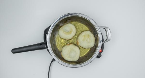 Togliere il coperchio, girare le frittelle e cuocere senza coperchio fino a doratura.