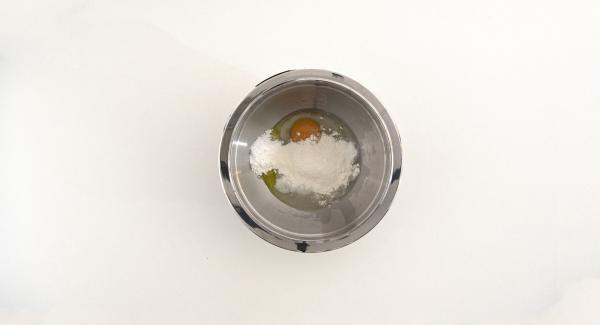 Versare in una Bacinella Combi 20 cm l’uovo, 1 cucchiaio di zucchero a velo, la vanillina, il lievito, l’olio evo e il succo di limone. Aggiungere la farina a pioggia e impastare.