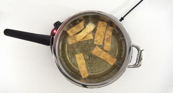 Al suono di Audiotherm, abbassare Navigenio a livello 4, rimuovere il coperchio e adagiare le striscioline di impasto all'interno della Padella. Coprire nuovamente con il coperchio, riposizionare Audiotherm sulla finestra “carne” e proseguire la cottura fino al raggiungimento del "punto di girata" (al nuovo suono di Audiotherm).
