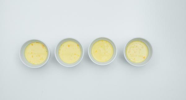 Mescolare lo zucchero rimanente con le uova e i tuorli. Unire il latte e la panna e versare il composto sul caramello.