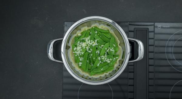 Togliere Navigenio, cospargere il pangrattato sulla pasta sfoglia, aggiungere le taccole, cospargere con la cipolla e il prosciutto. Versare l'impasto con l'uovo,  distribuire il formaggio e spegnere fornello.