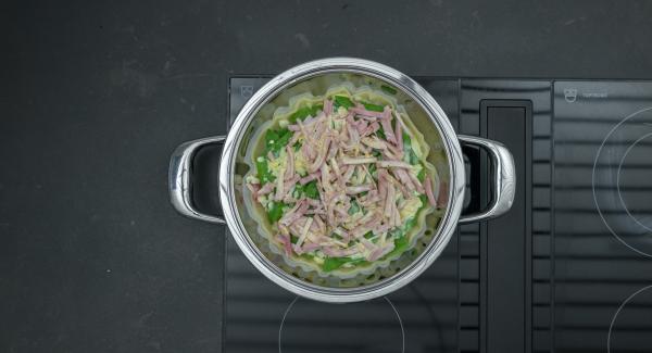 Togliere Navigenio, cospargere il pangrattato sulla pasta sfoglia, aggiungere le taccole, cospargere con la cipolla e il prosciutto. Versare l'impasto con l'uovo,  distribuire il formaggio e spegnere fornello.