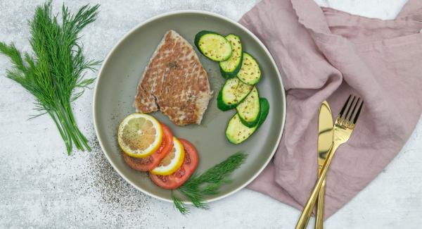 Servire il tonno con le zucchine come contorno insieme ai pomodori e al limone. Guarnire con le spezie.