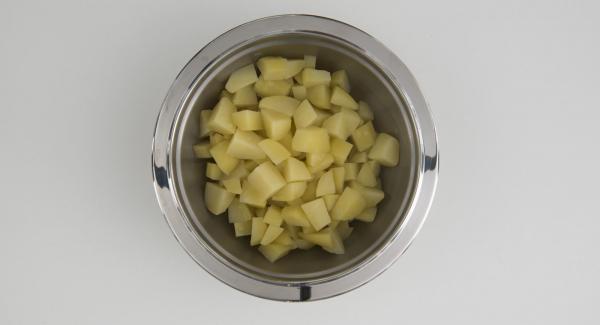 Pelare e tagliare le patate a cubetti. Tritare il prezzemolo con l'ausilio di Tritamix. Tagliare il sedano a pezzetti. Tagliare un foglio di carta forno dello stesso diametro del coperchio.